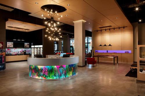 a lobby with a waiting area with a table at Aloft Coral Gables in Miami