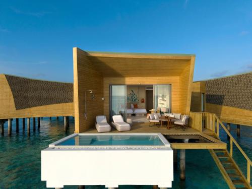 a house on the water with a swimming pool at Centara Mirage Lagoon Maldives in Nakachchafushi
