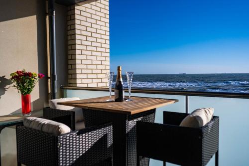 a table and chairs with a view of the ocean at Wight Stone Luxury Townhouse - Breathtaking Views in Sandown