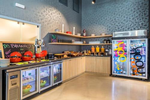 Aloft Montevideo Hotel في مونتيفيديو: مطبخ مع ثلاجة وطاولة طعام