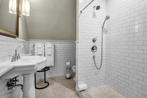 a white bathroom with a sink and a shower at InnBuffalo Off Elmwood in Buffalo
