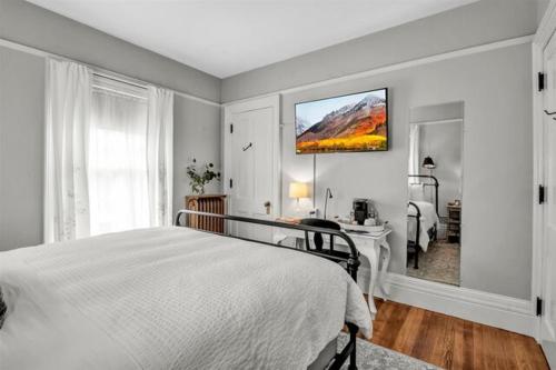 a white bedroom with a bed and a desk in it at InnBuffalo Off Elmwood in Buffalo