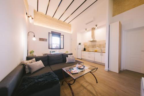 een woonkamer met een bank en een tafel bij Miraflores 58 Apt - Private Parking Opt in Sevilla