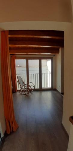an empty room with a chair in front of a window at Ca la Mariana in Organyà