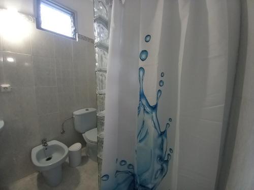 a bathroom with a shower curtain with a toilet and a sink at Casa Tomás - Zona Rural in Fasnia