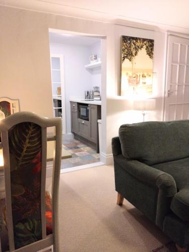 a living room with a couch and a kitchen at Beachfront Studio Apartment in Felixstowe