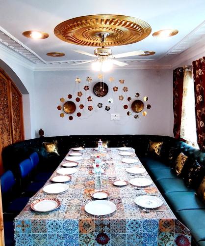 a dining room with a long table with plates at Waneposh in Srinagar
