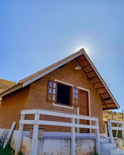a small house with a porch and a window at Pousada Villa's Hortelã in Passa Quatro