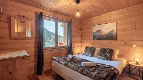 une chambre avec un lit dans une cabane en bois dans l'établissement Le Refuge Alpin, au Grand-Bornand