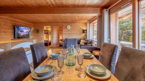 une salle à manger avec une table et des chaises en bois dans l'établissement Le Refuge Alpin, au Grand-Bornand