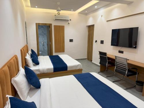 a hotel room with two beds and a television at Hotel Taj Way by Jyoti Villa in Agra
