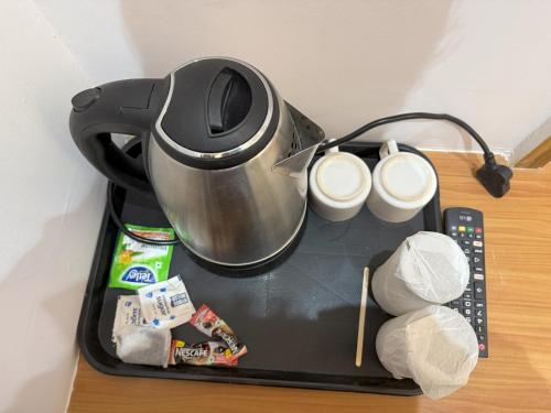 a tea kettle on a tray on a table at Hotel Taj Way by Jyoti Villa in Agra