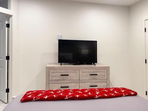 a flat screen tv sitting on top of a dresser at COZY LOON MOUNTAIN ESCAPE - Free shuttle, Pool, Hot tub, River&Mnt Views in Lincoln