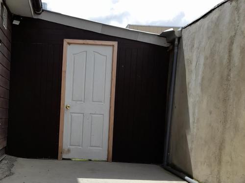a garage with a white door and a black wall at Casa familiar in Punta Arenas