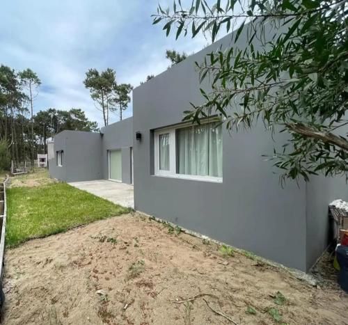 a white house with a driveway at Chalet Sebastian II in Pinamar