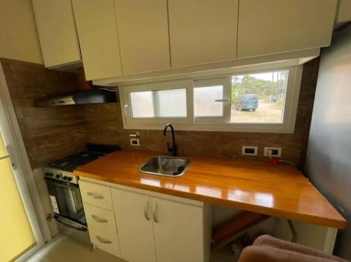 a small kitchen with a sink and a window at Chalet Sebastian II in Pinamar