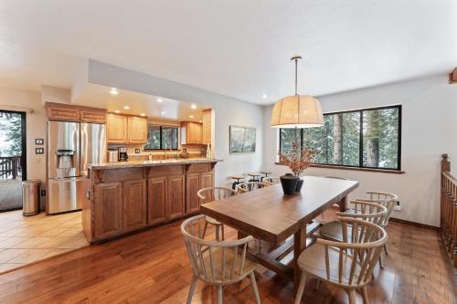 eine Küche und ein Esszimmer mit einem Holztisch und Stühlen in der Unterkunft The Pinecrest Retreat- 10 mins to NorthStar! Hot Tub, Large Deck, Views, and Games in Tahoe Vista