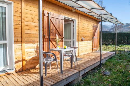 a wooden deck with a table and chairs on it at O Cuend'U Lac in Osséja