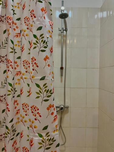 - un rideau de douche avec un motif floral dans la salle de bains dans l'établissement Le nid douillet, à Le Coteau