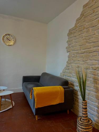 - un salon avec un canapé bleu et une couverture jaune dans l'établissement Le nid douillet, à Le Coteau