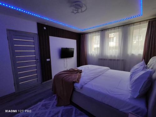 a bedroom with a bed and a blue light at Studio Vale in Hunedoara