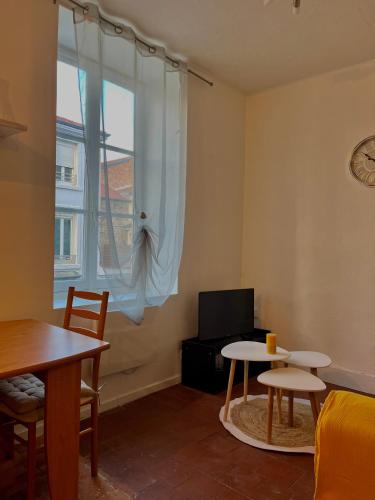 un salon avec une table et une fenêtre dans l'établissement Le nid douillet, à Le Coteau