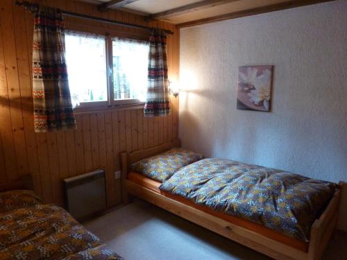 een kleine slaapkamer met een bed en een raam bij Alpenrösli in Schwarzsee