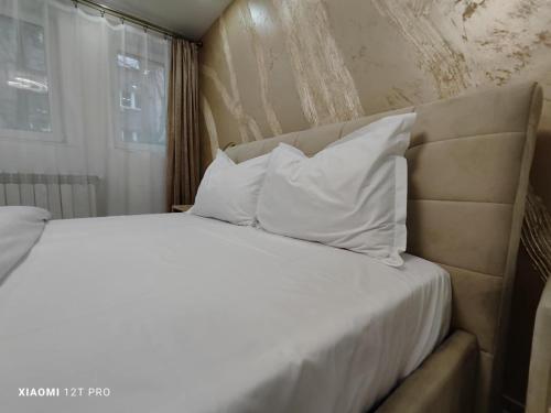 a bed with white sheets and pillows in a bedroom at Studio Vale in Hunedoara