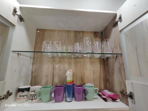 a shelf with glasses sitting on top of a counter at Studio Vale in Hunedoara