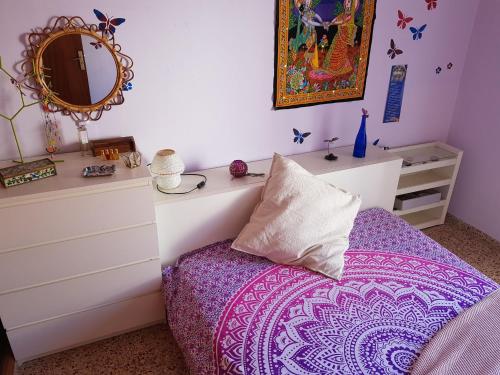 a bedroom with a bed with a mirror and a dresser at The Magic Dragonfly in Santa Cruz de Tenerife