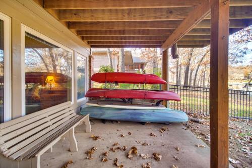 a covered porch with a bench and pillows at Lakefront Home with Furnished Deck in Grove! in Grove