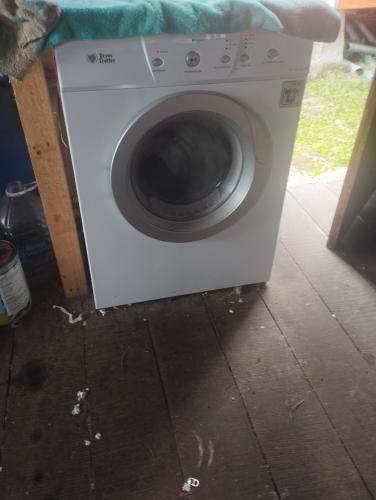 a washing machine sitting on the floor in a room at El Descanso in Queilén