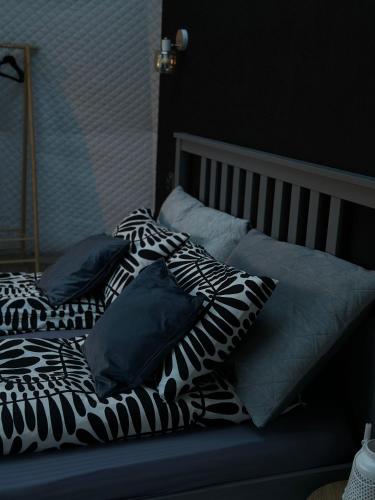 a bed with black and white pillows on it at The Frog Glamping in Horezu