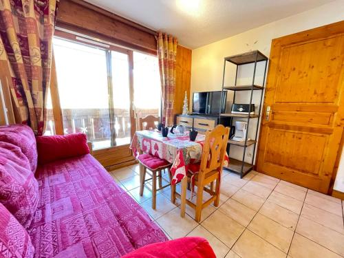 un salon avec une table et un canapé dans l'établissement Appartement cosy au pied des pistes avec balcon - FR-1-505-220, à Flumet