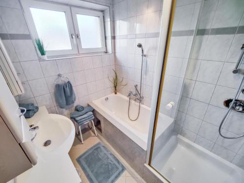 a bathroom with a tub and a toilet and a sink at Ferienwohnung Nussbaumblick in Ottensheim