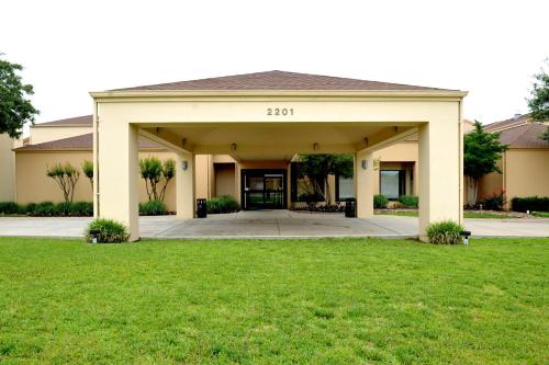 a home with a large garage with a lawn at Courtyard by Marriott Dallas-Fort Worth/Bedford in Bedford