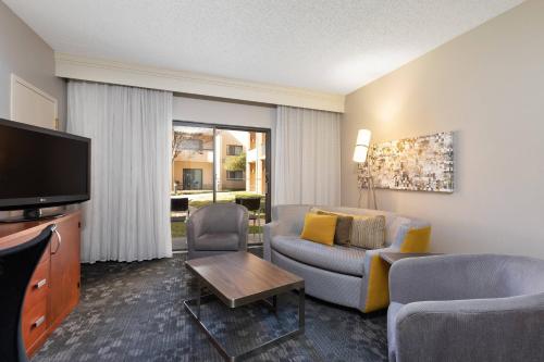 a living room with a couch and a tv at Courtyard by Marriott Dallas-Fort Worth/Bedford in Bedford