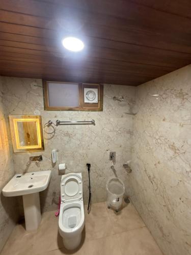 un baño con lavabo e inodoro en OMT Stays & Café, en Manali