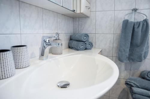 a bathroom with a white sink and blue towels at Ferienwohnung Nussbaumblick in Ottensheim