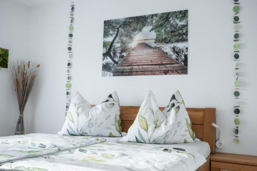 a bedroom with a bed with a picture on the wall at Ferienwohnung Nussbaumblick in Ottensheim