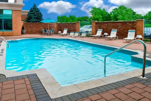 a large swimming pool with chairs and umbrellas at Courtyard by Marriott Niagara Falls in Niagara Falls
