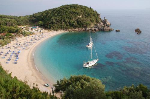 a boat sitting in the water on a beach at Aspri Villa in Ammoudia