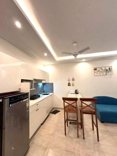 a kitchen with two chairs and a table and a couch at Riviera Sublime Holiday Homes in Siolim