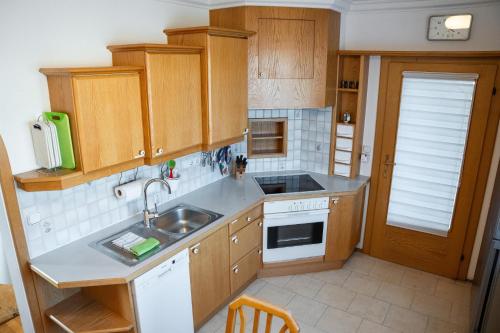 a kitchen with wooden cabinets and a sink at Ferienwohnung Nussbaumblick in Ottensheim