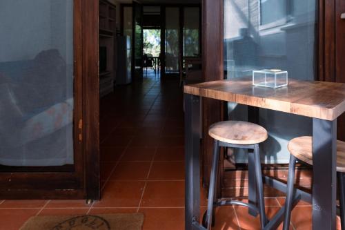 a wooden bar with two stools in a room at Villa Gianto pool & spa in Polignano a Mare