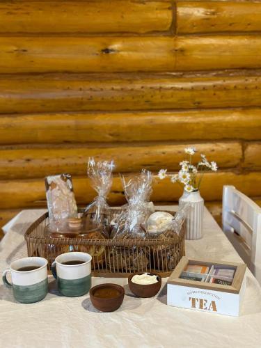 un tavolo con un cesto di tè e tazze sopra di Cabañas Laguna de los Sauces ad Azul