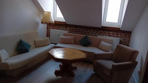 a living room with a couch and two chairs and a table at Stellas Monteurwohnungen in Crimmitschau