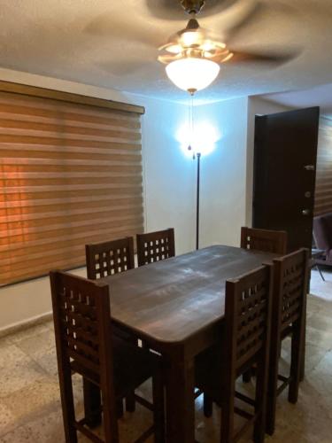 a dining room with a wooden table and chairs at Casa Brisas-Mérida Yucatán in Mérida