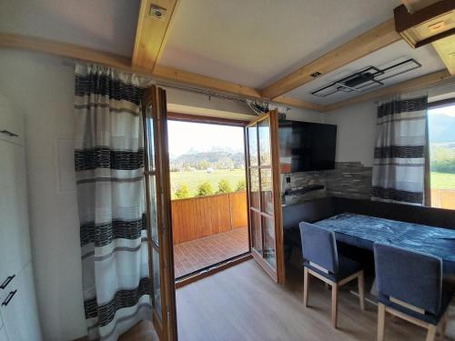 a kitchen and dining room with a table and a balcony at Haus Wastl in Seebach