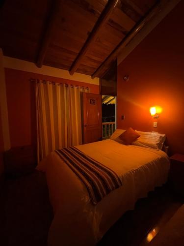 a bedroom with a bed in a room with a window at SARA GARDEN LODGE Ollantaytambo in Ollantaytambo